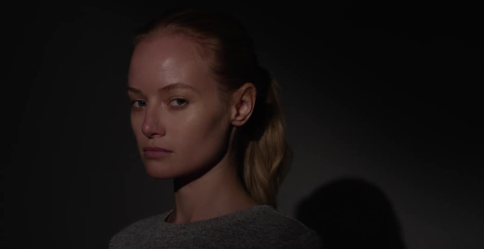 Light briefly illuminates a woman's face