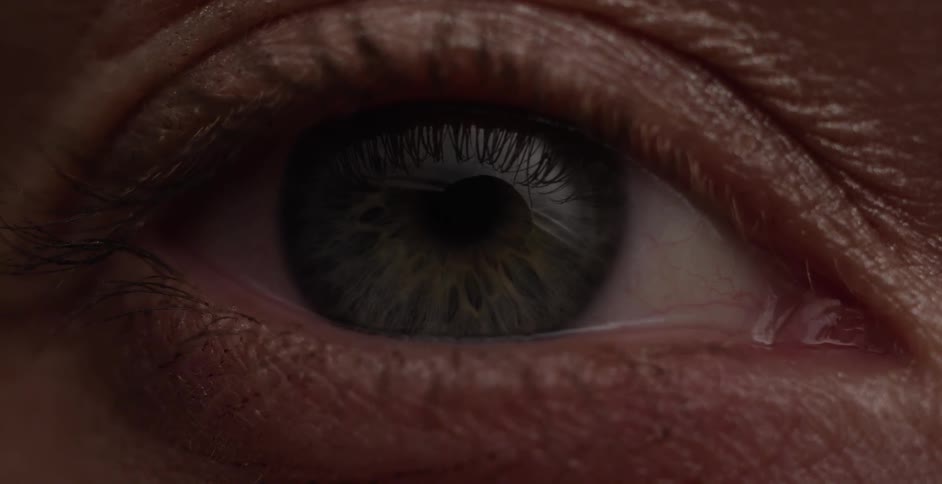 A blue green eye opens and closes