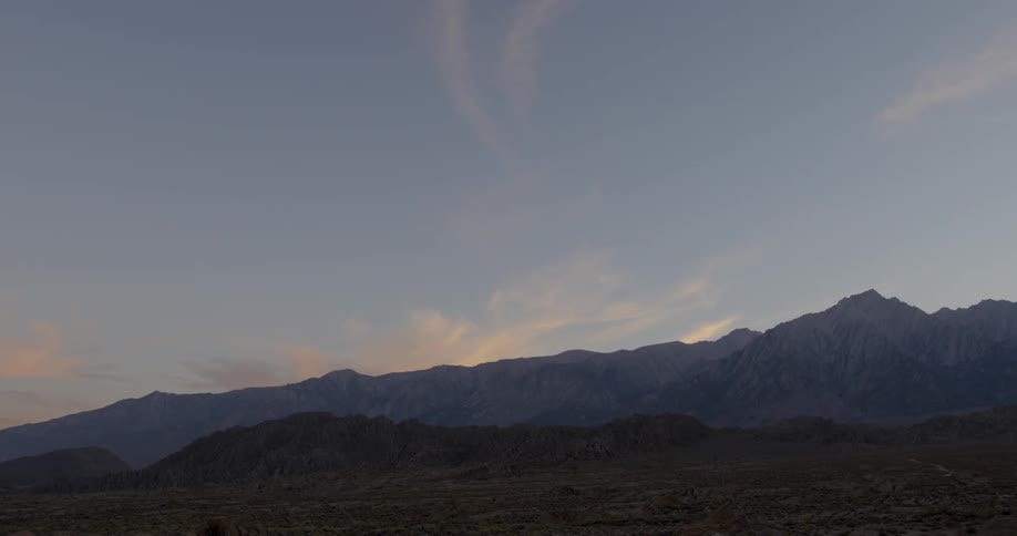 A mountain ridge line on the horizon at sunset