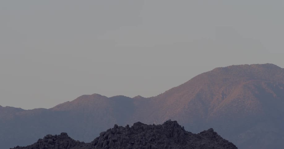 A mountain is in the far distance at sunset