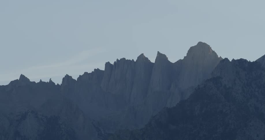 A steep jagged mountain range is in the distance
