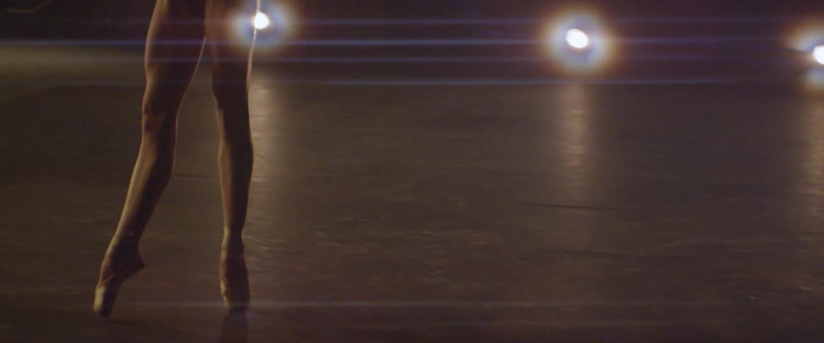 Woman practices ballet moves on a stage