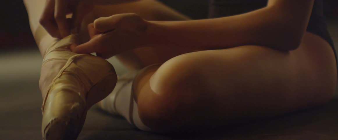 A ballerina adjusts her shoes