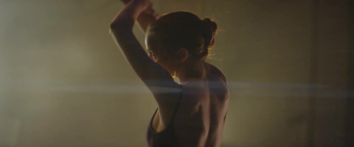 A woman stretches on stage