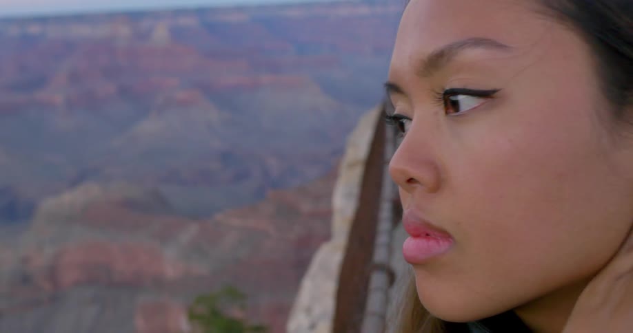 Woman wipes the hair from her face as she enjoys a view