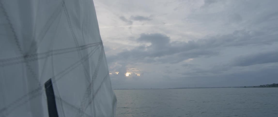 A sail flapping in the breeze on the ocean