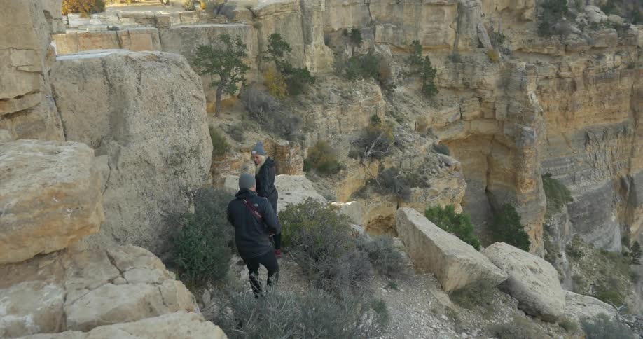 A man and woman hike over rocks on a mountain