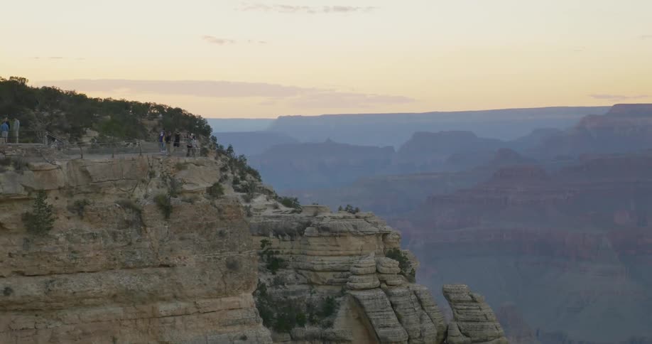 A view of people gathered on the edge of a cliff in the mountains