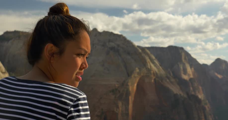 Woman looking at mountains turns to her side and talks