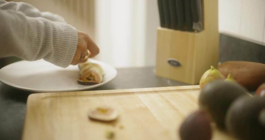 Woman transfers eggplant from a chopping board to a plate