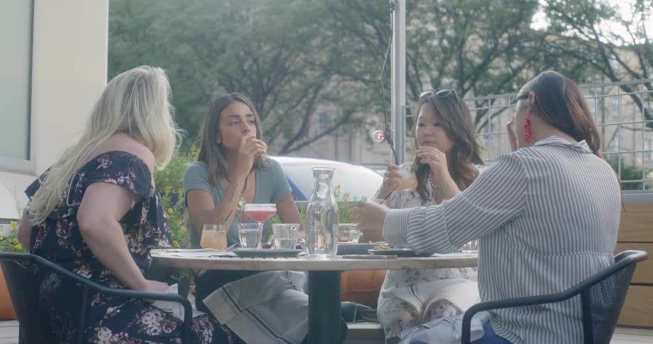 A group of women dine at a patio table