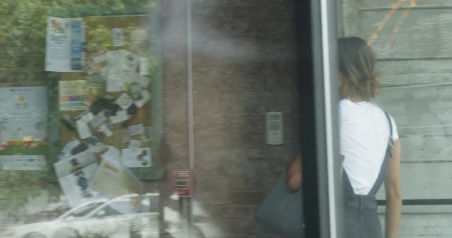 A woman is walking into a coffee shop during the day