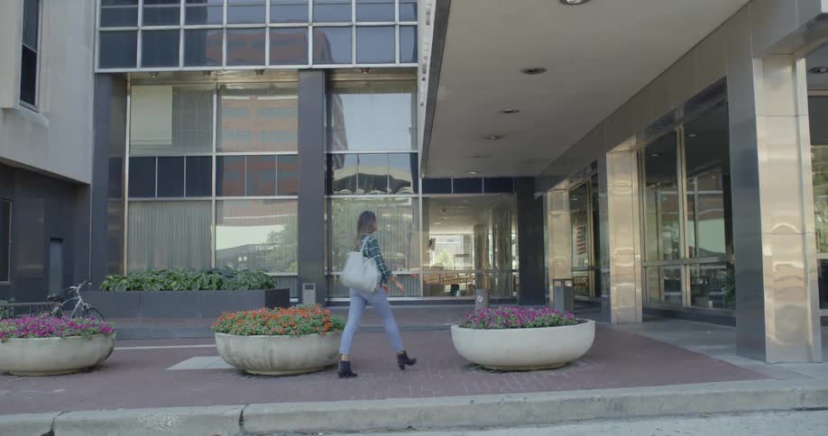 A woman walks down a city sidewalk