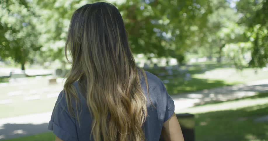 A woman walks through a cemetery