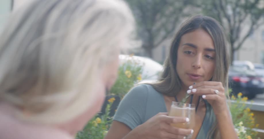 Women drink cocktails on an outdoor patio