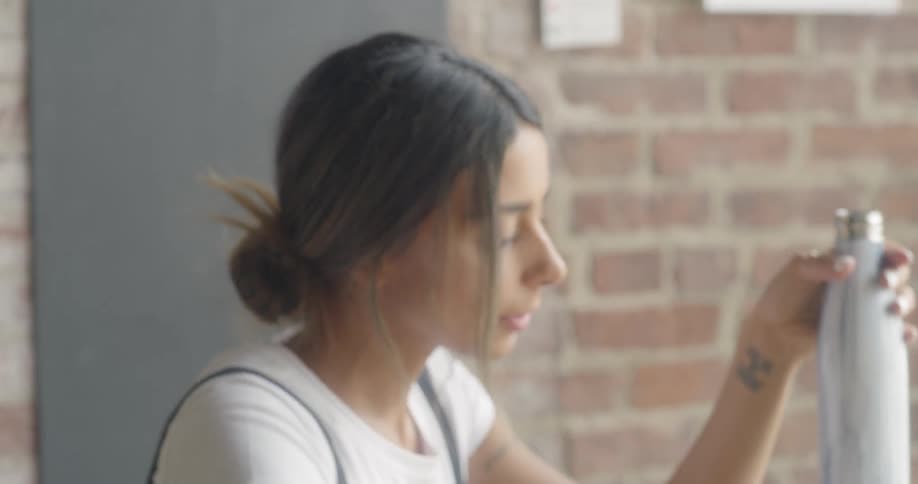 A woman drinks from a water bottle