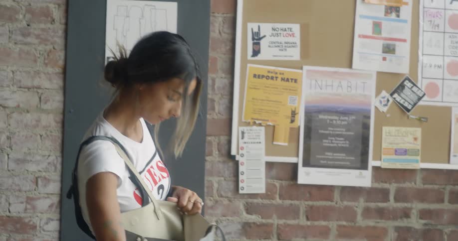 Woman removes her laptop from a bag and places it on a table
