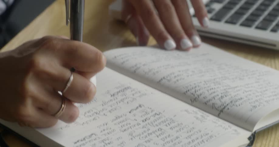 A woman writes in a notebook