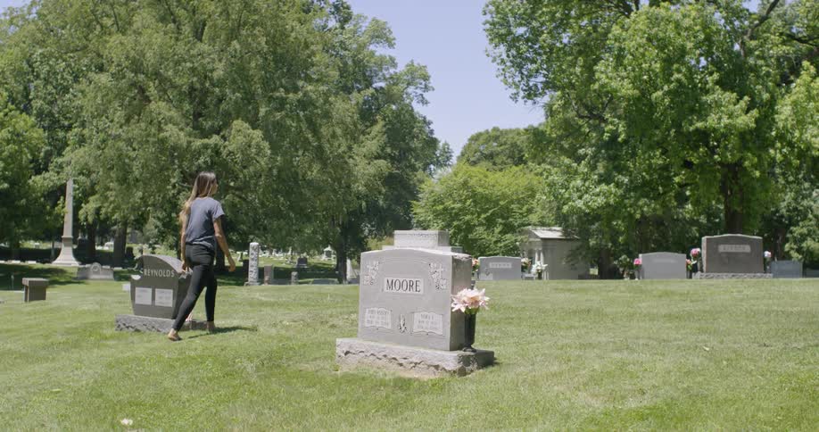 A woman walks through a cemetery