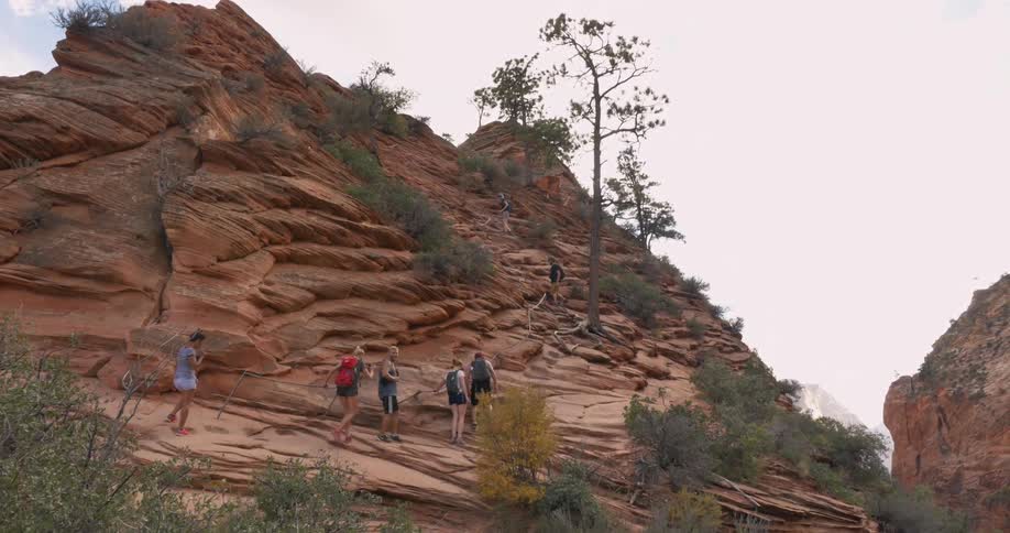 A group of people hiking up a rock hill
