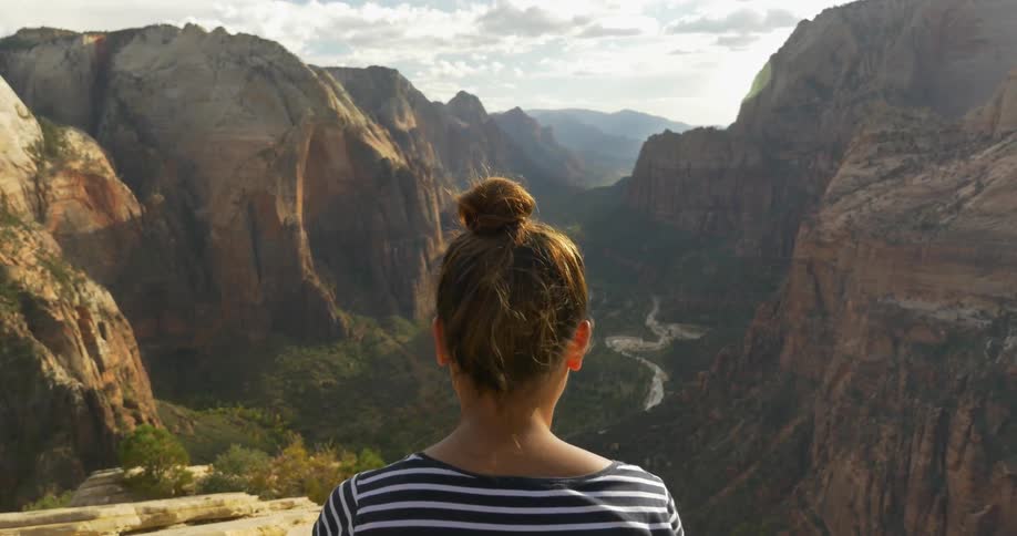 A woman looks out over a mountain valley