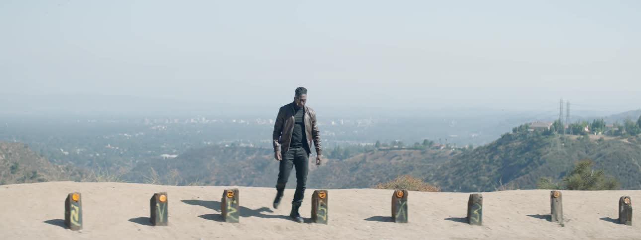 A man standing at an overlook turns and walks away
