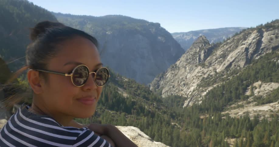 Woman looks over at some mountains then turns and smiles