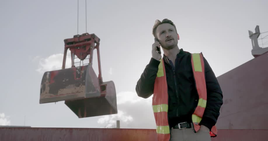 A construction worker talks on his phone