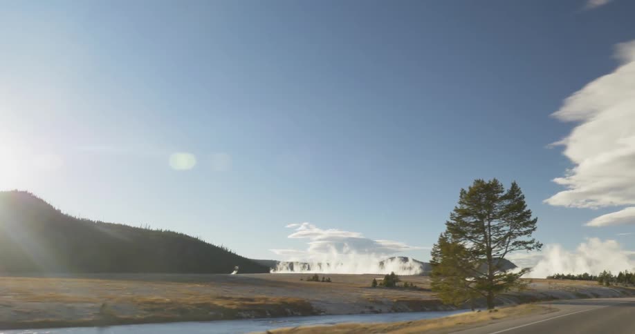 Small body of water with steam coming out of the ground across it
