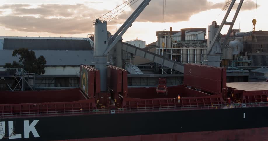 A container ship is being viewed at sunset