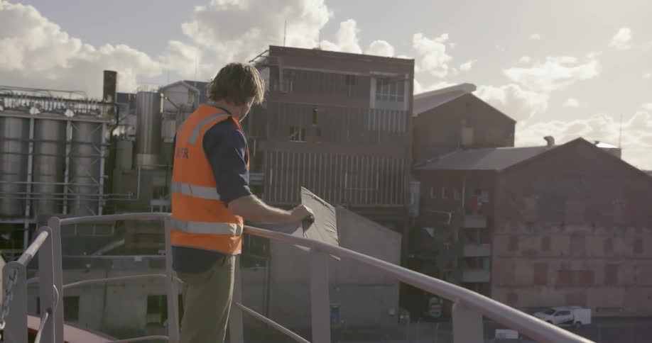 Man climbs up on a ship looking out