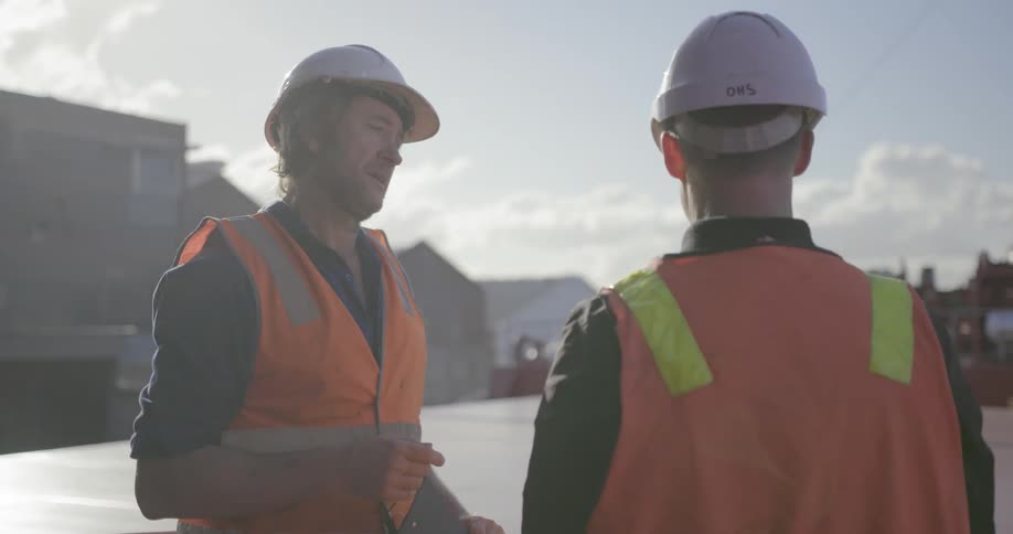 Two people are discussing something on the deck of a ship