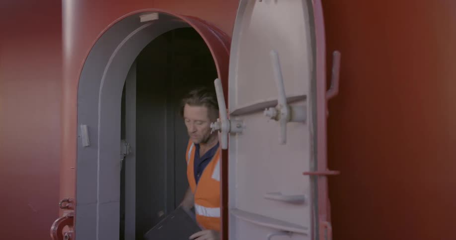 Man climbs down a ladder and walks onto the ship deck