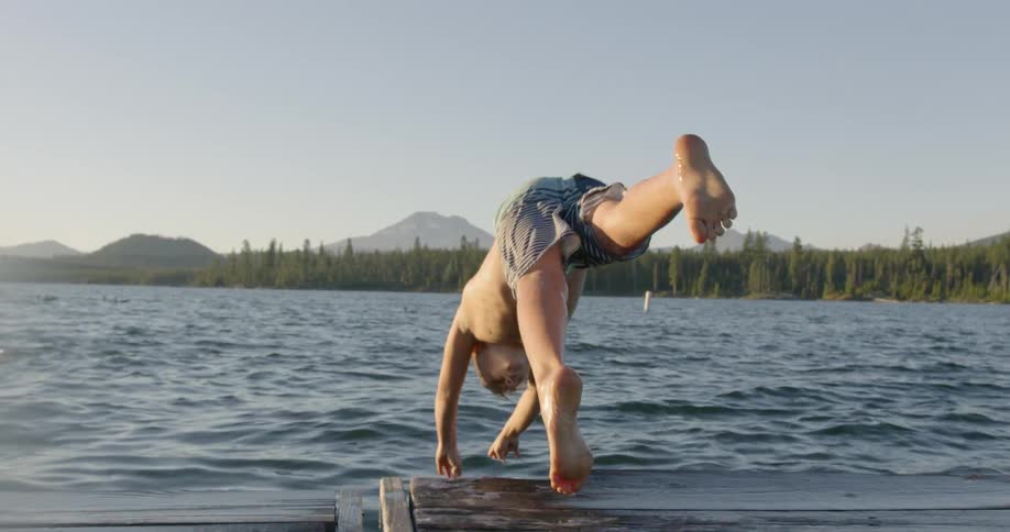 A man dives off the pier into the water