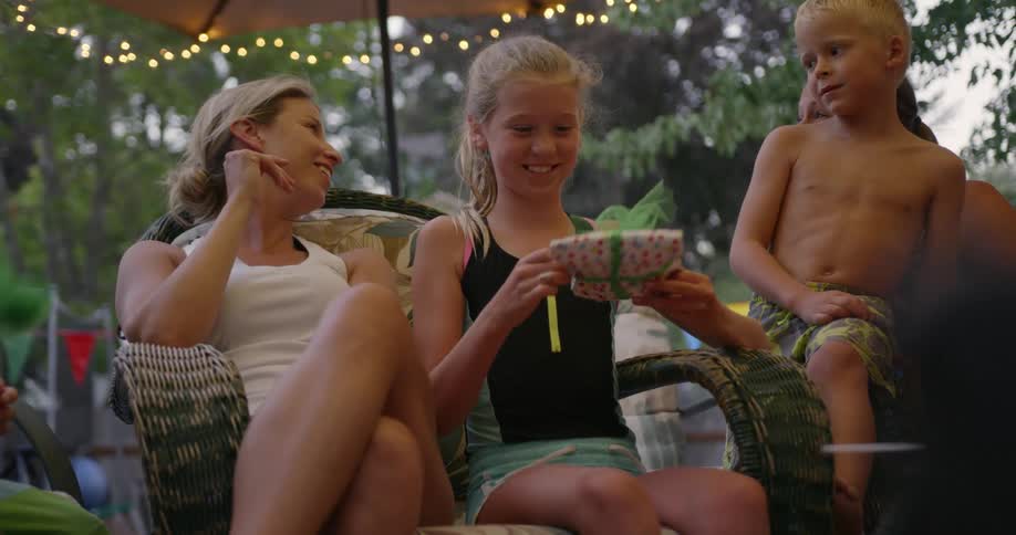 A girl unwraps a present at a party