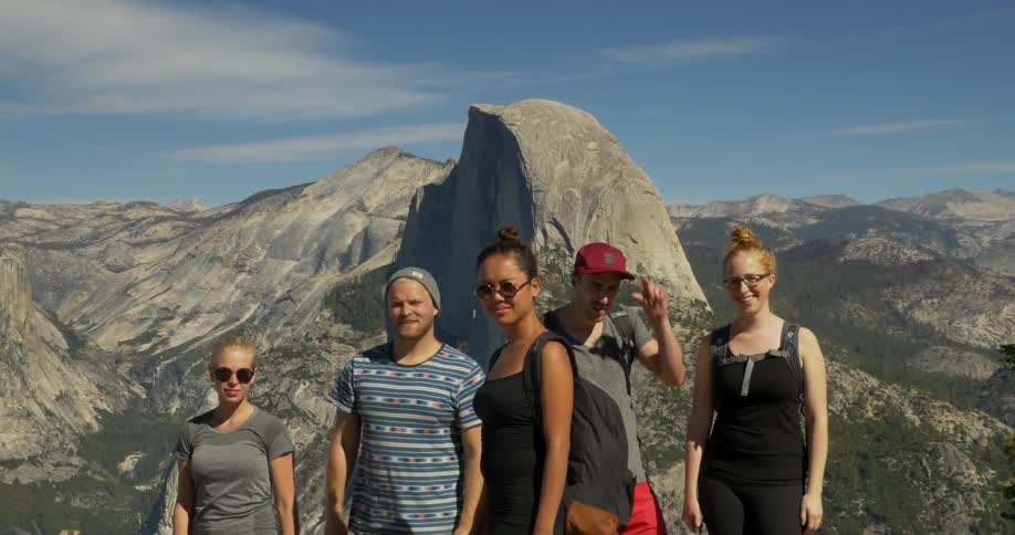 A group of people pose in front of a mountain range
