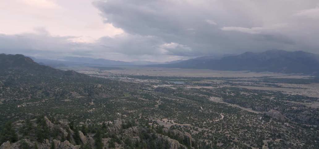 The hills are covered with trees above the valley