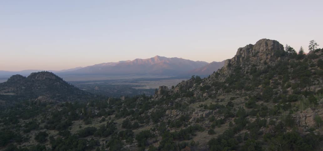 A rocky mountainside is shown at sunrise