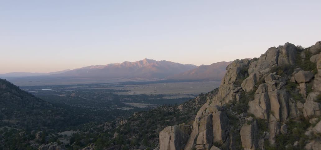 A rocky mountainside is shown at sunrise