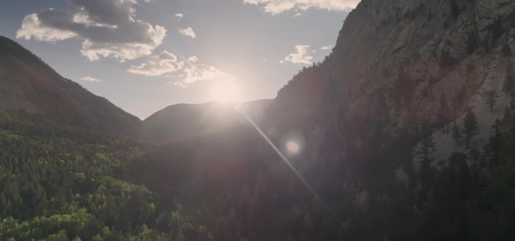 The sun shines between the mountains