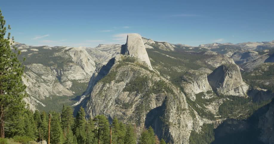 Some trees line the front of a large mountain range