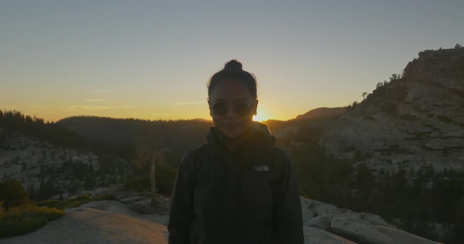 Woman standing on a mountain as the sun sets