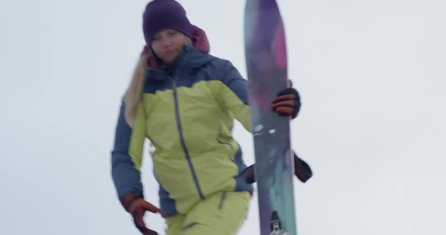 Woman passes skis down from top of jeep roof rack