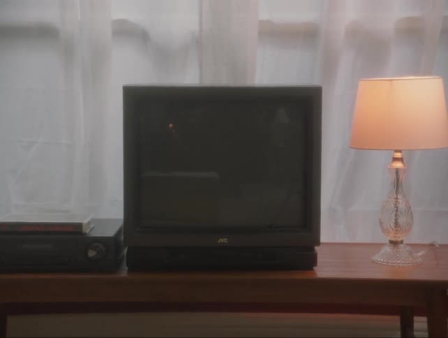 The lamp is turned on near the television