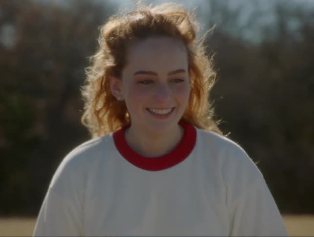 A woman smiles as the wind blows her hair