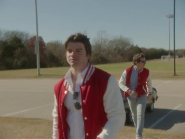 Two high school athletes walk in the parking lot