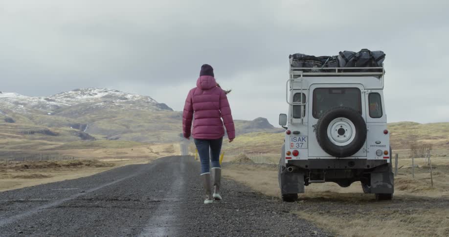 A woman walks over to her land rover vehicle
