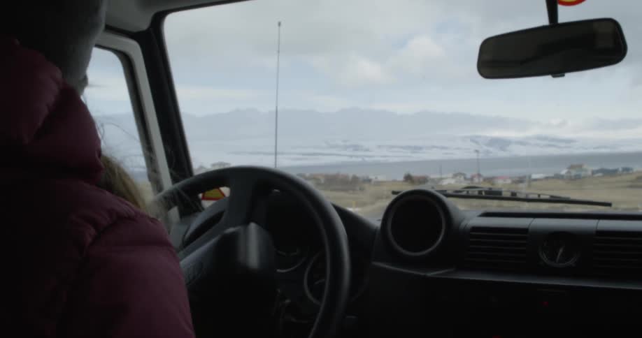 A woman turns onto a road and pulls over and stops