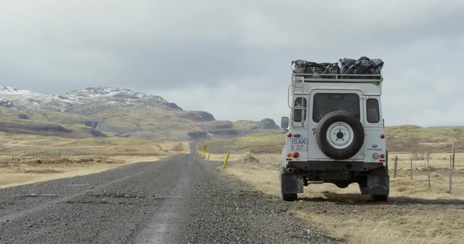 A white truck sits parked on the side of a lonely mountain road