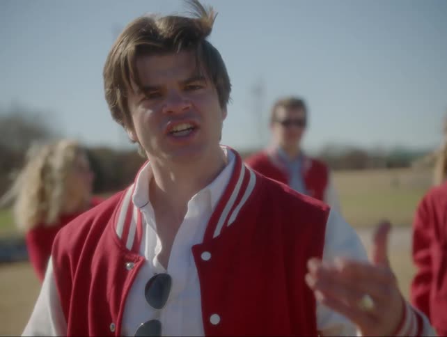 A teenage boy looks angry while he talks outside